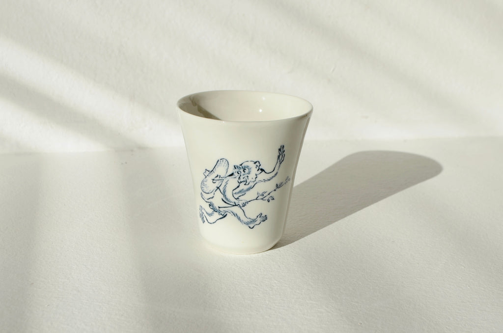 Porcelanasta skodelica z motivom opice